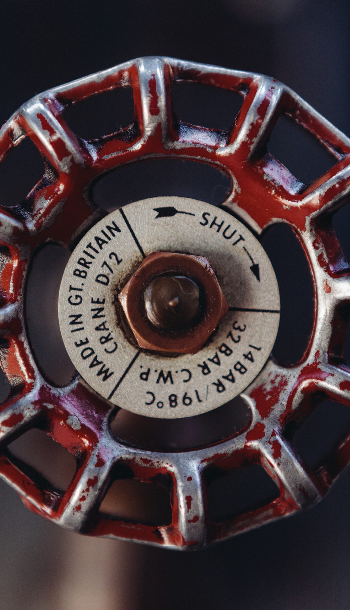Close-up of a red cast-iron stopcock valve wheel